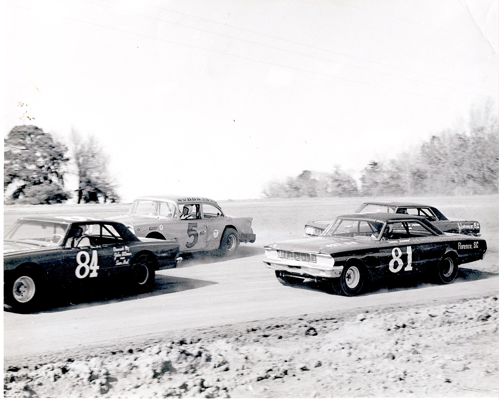 Sam Ard leads his teammates Jimmy Hatchell and Junior Johnson around Bubba Into at either…