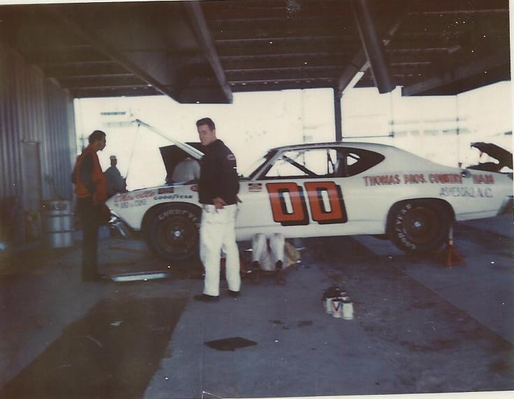 FEB.16, 1973 SAM ARD UNDER CAR WORKING ON IT GETTING READY FOR 2-17-1973 DAYTONA RACE…
